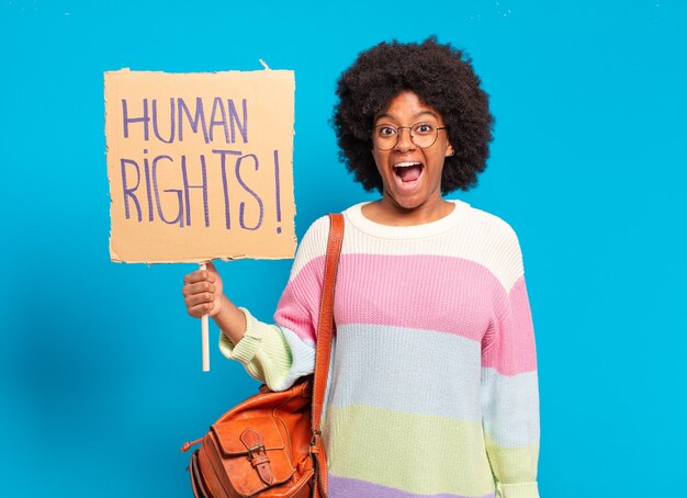 Young pretty afro woman protesting with human rights banner