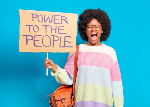 Young pretty afro woman protesting with a power to the people