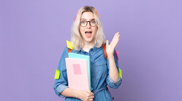 Young pretty albino woman feeling happy and astonished at something unbelievable. student concept