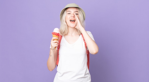 young pretty albino woman feeling happy,giving a big shout out with hands next to mouth .summer concept