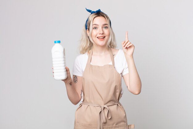 young pretty albino woman feeling like a happy and excited genius after realizing an idea with a bottle of milk