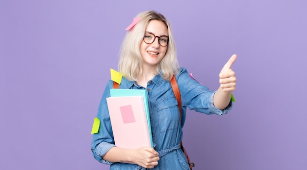 Young pretty albino woman feeling proud,smiling positively with thumbs up. student concept