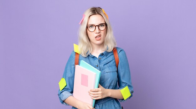 Young pretty albino woman feeling puzzled and confused. student\
concept