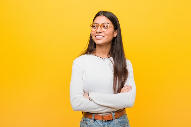 Young pretty arab woman against a yellow  smiling confident with crossed arms.