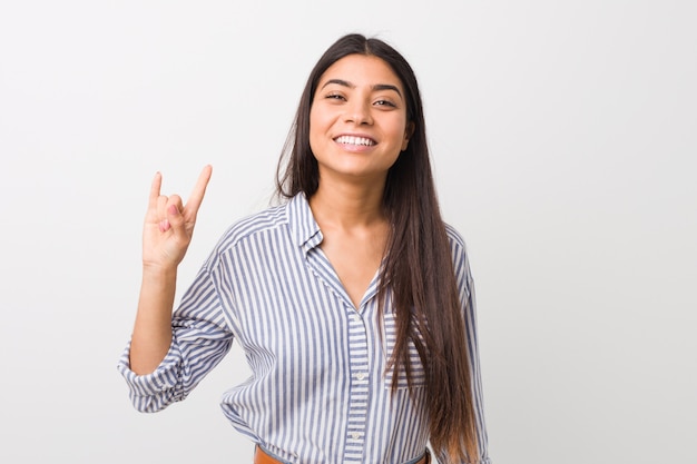 Young pretty arab woman showing a horns gesture as a revolution concept.