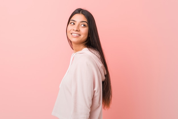 Young pretty arab woman wearing a casual sport look looks aside smiling, cheerful and pleasant.