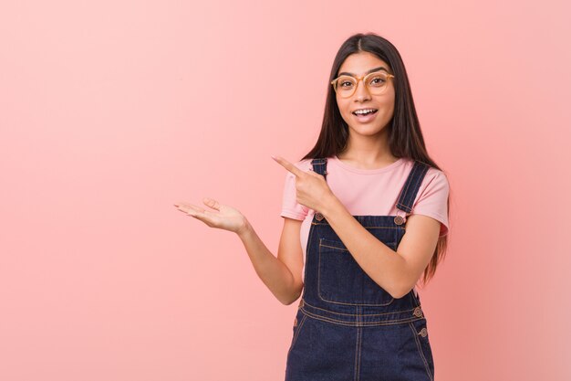 Young pretty arab woman wearing a jeans dungaree excited 