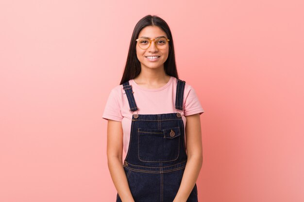 Young pretty arab woman wearing a jeans dungaree happy, smiling and cheerful