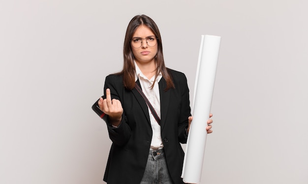 Photo young pretty architect woman feeling angry, annoyed, rebellious and aggressive, flipping the middle finger, fighting back