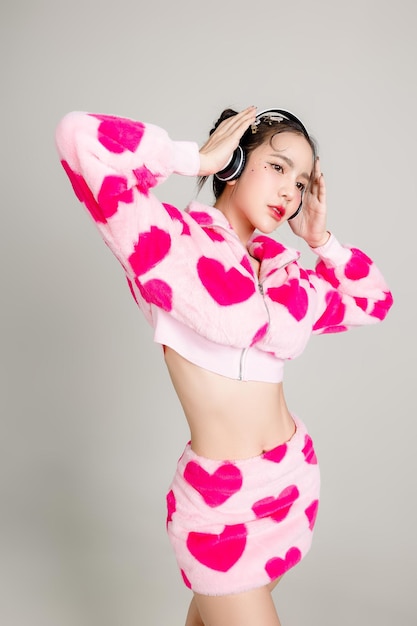 Young Pretty Asian woman have prefect slim fit body in heart print dress and headphone with makeup on face isolated on white background Valentine love plastic surgery concept