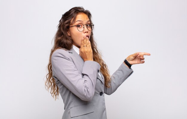 young pretty astonished businesswoman with glasses