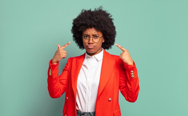 young pretty black businesswoman pointing at herself