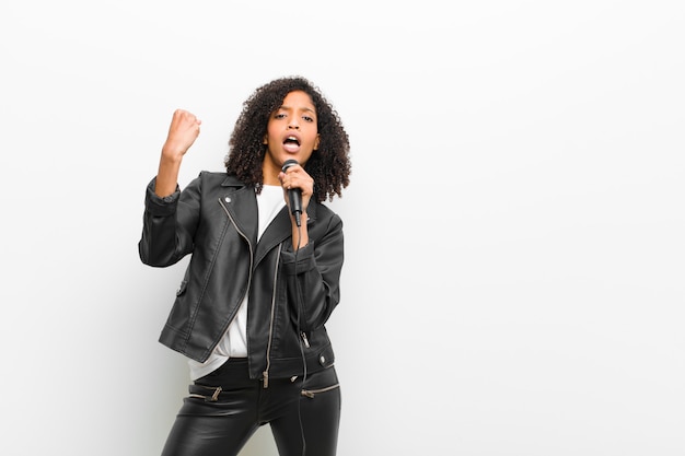 Young pretty black woman with a microphone wearing a leather jacket