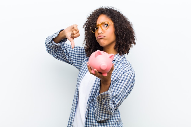 Young pretty black woman with a piggy bank