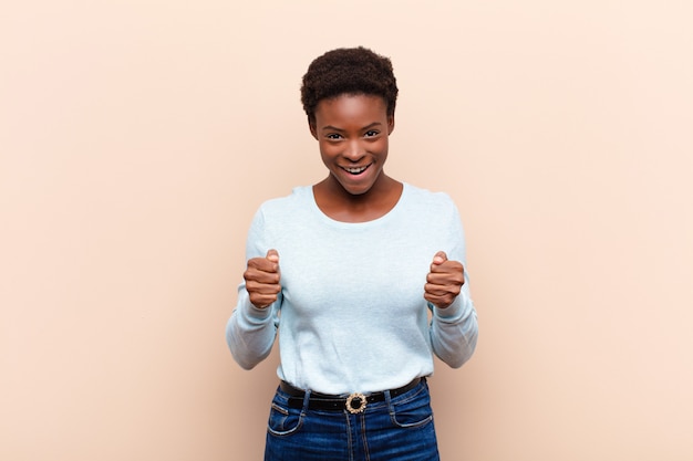 Giovane donna di colore piuttosto scioccata, eccitata e felice, che ride e celebra il successo, dicendo wow!