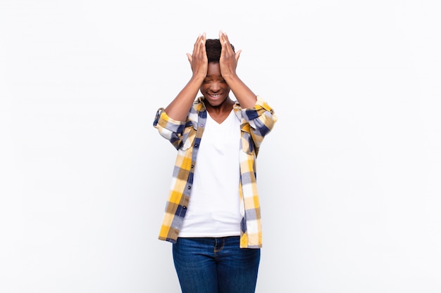 Young pretty black womanfeeling stressed and anxious, depressed and frustrated with a headache, raising both hands to head