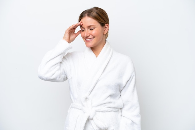 Young pretty blonde woman in bathrobe isolated on white background smiling a lot