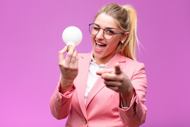 Young pretty blonde woman having an idea with a light bulb