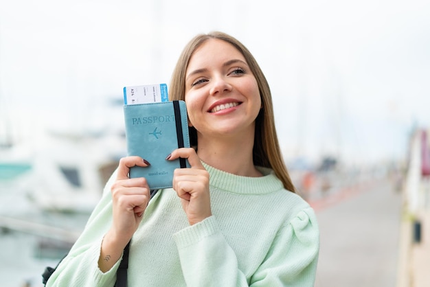 Фото Молодая симпатичная блондинка с паспортом со счастливым выражением лица