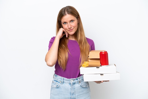 Young pretty blonde woman holding fast food isolated on white background laughing