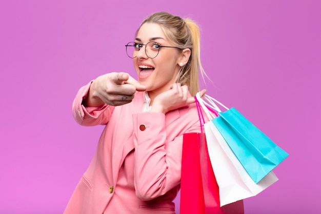 Young pretty blonde woman holding shopping bags