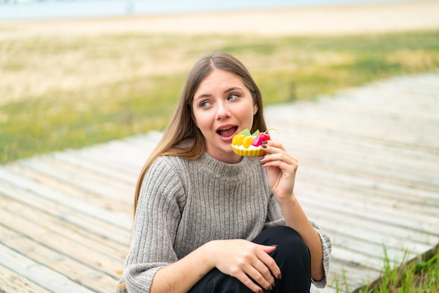 tartlet을 들고 젊은 예쁜 금발의 여자