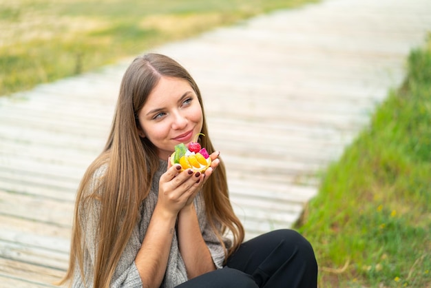 Young pretty blonde woman holding a tartlet