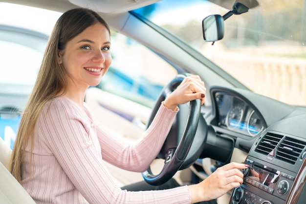 車の中の若いきれいなブロンドの女性