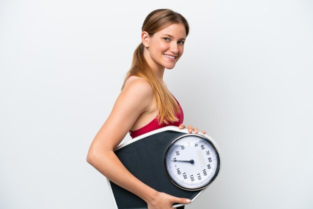 Young pretty blonde woman isolated on white background with weighing machine