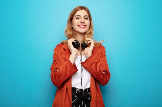 Young pretty blonde woman listening music with a headphones