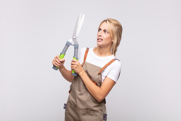 Young pretty blonde woman with a pruning shears