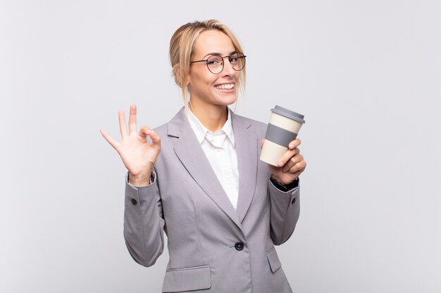 Young pretty blonde woman with a take away coffee