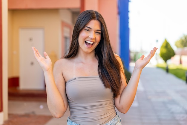 Young pretty Brazilian woman at outdoors smiling a lot