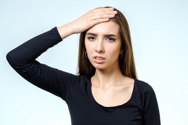 young pretty brunette girl touching her head