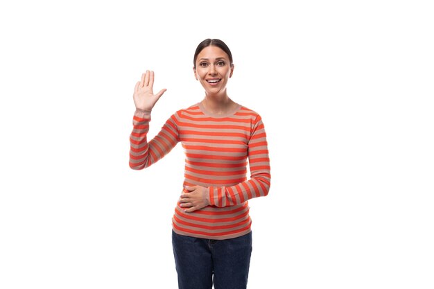 Young pretty brunette lady dressed in a casual striped blouse points her finger to the side