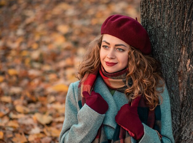 Young pretty brunette woman with curly hair posing while looking dreamiliy upwards.