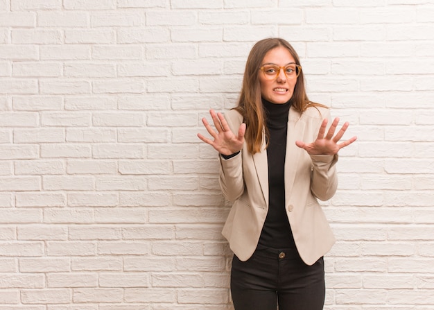 Young pretty business entrepreneur woman rejecting something doing a gesture of disgust