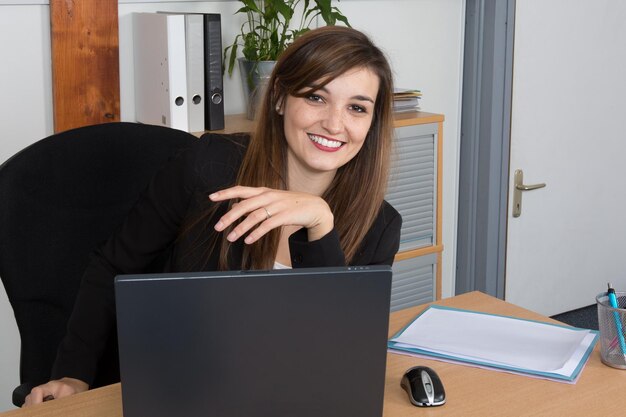 Young pretty business woman with notebook in the office