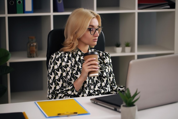 Photo young pretty business woman with notebook in the office