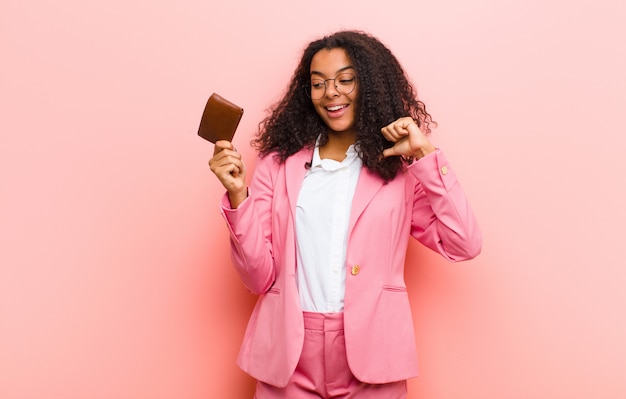 Young pretty business woman with a wallet against pink wall