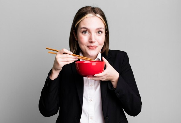 Young pretty businesswoman eating ramen noodles bowl