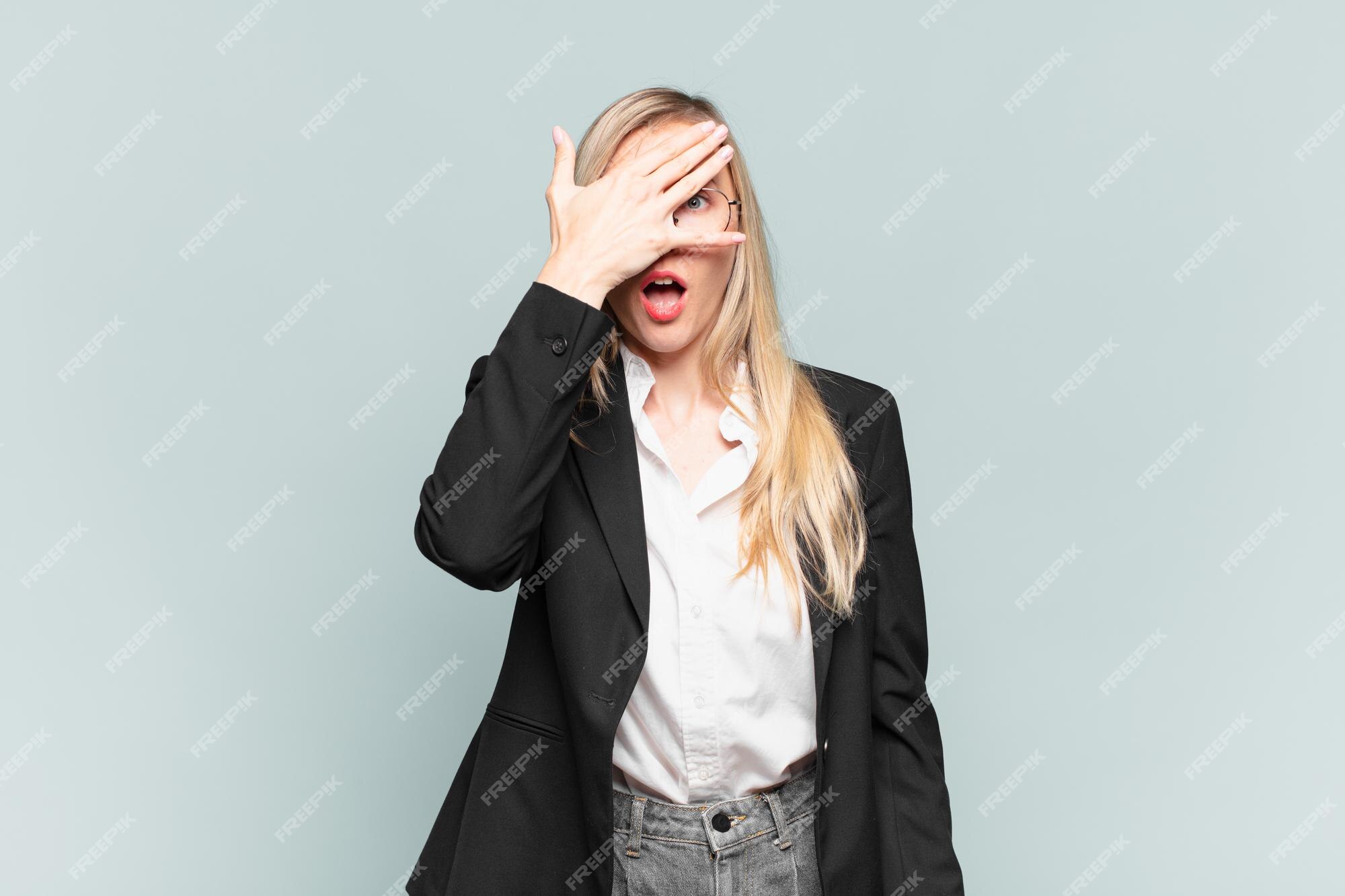 Tight cropped face of a scared young girl with hands covering