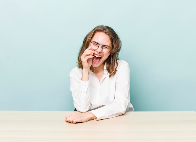 Young pretty businesswoman sitting with a table