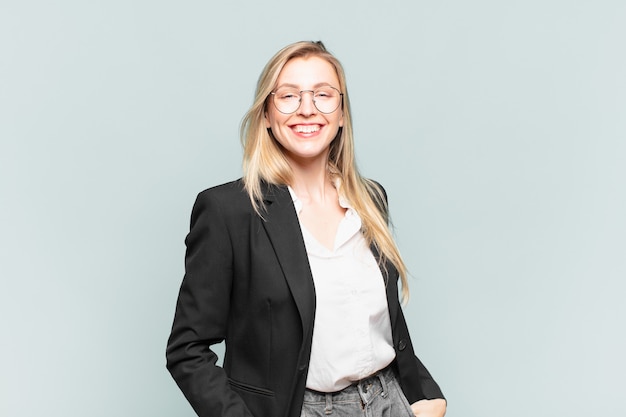 Young pretty businesswoman smiling cheerfully and casually with a positive, happy, confident and relaxed expression