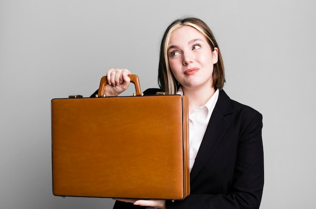 Young pretty businesswoman with a leather suitcase