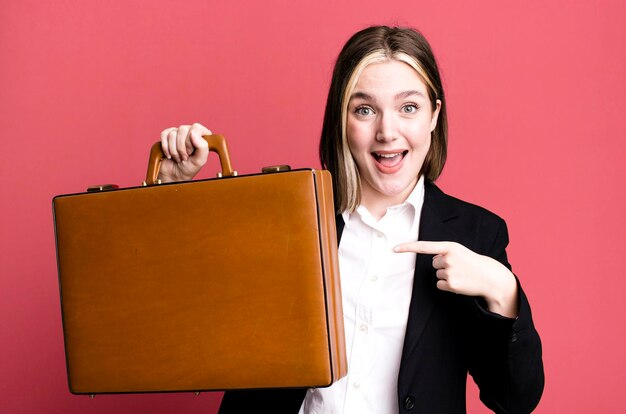 Photo young pretty businesswoman with a leather suitcase