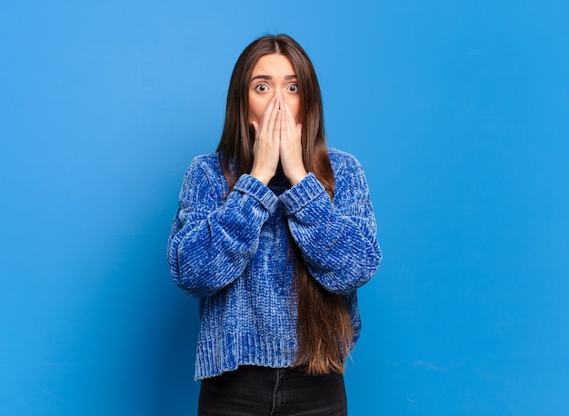 Young pretty casual woman feeling worried, upset and scared, covering mouth with hands, looking anxious and having messed up