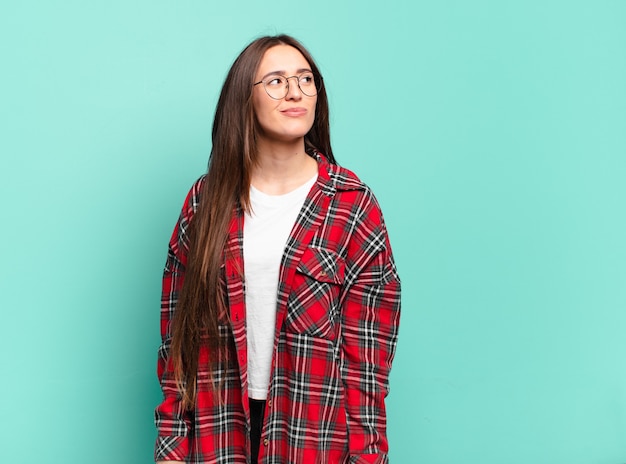 Young pretty casual woman looking puzzled and confused, wondering or trying to solve a problem or thinking