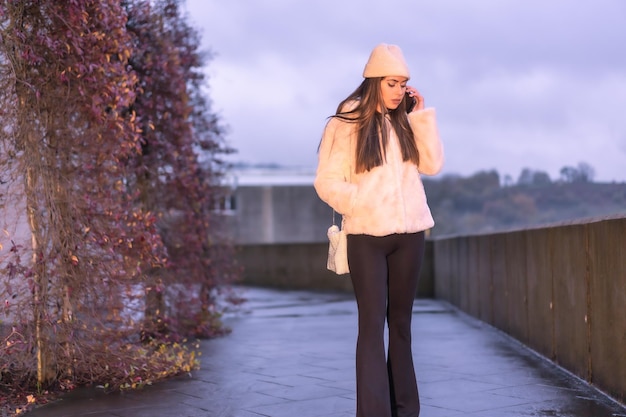 Giovane bella bruna caucasica che cammina in città in inverno indossando un maglione di lana rosa