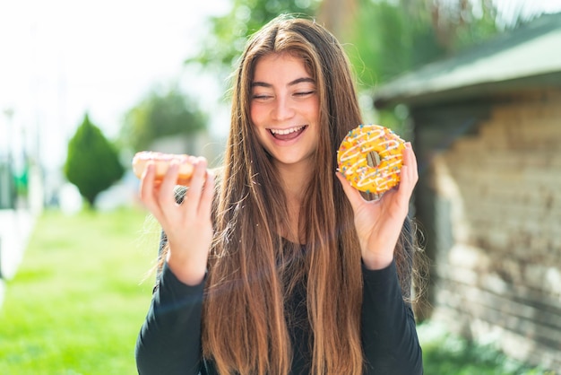 Young pretty caucasian woman holding donuts with happy expression